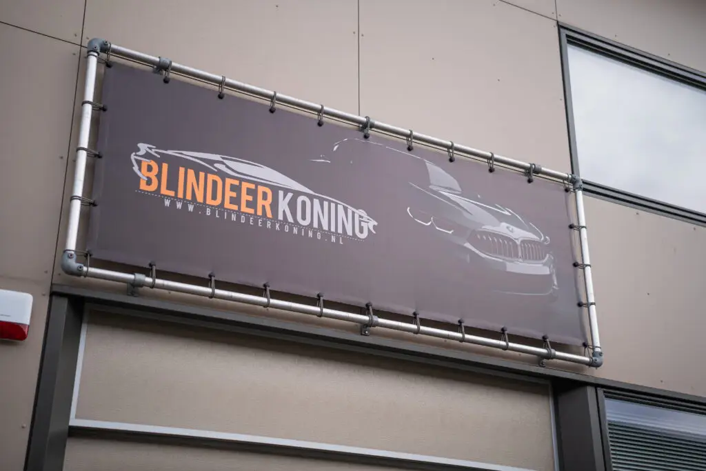 Banner met het logo van Blindeer Koning op de gevel van het pand
