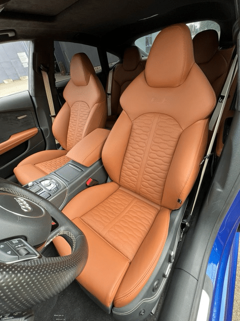 Cognackleurige autobekleding op de voorstoelen en achterbank